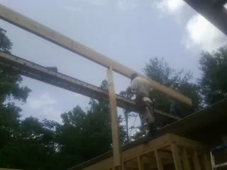 Carpenter setting a ridge beam over a new addition frame — Ice Dam Removal by Roofing Brothers in Beaver Crossing
