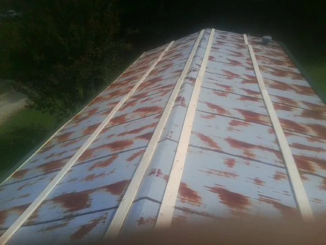 Rusted metal roof panels with new wood purlins before replacement — Storm Damage Roof Repair in Beaver Crossing by Roofing Brothers