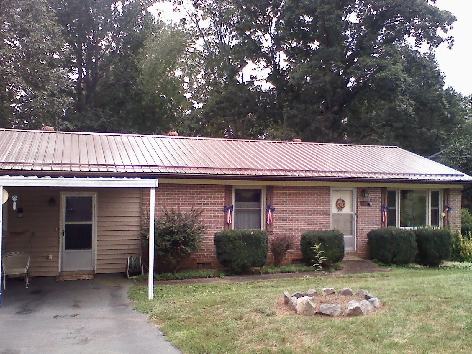 Bronze metal roof and carport on a brick ranch home — Roof Repair work by our crew in Beaver Crossing